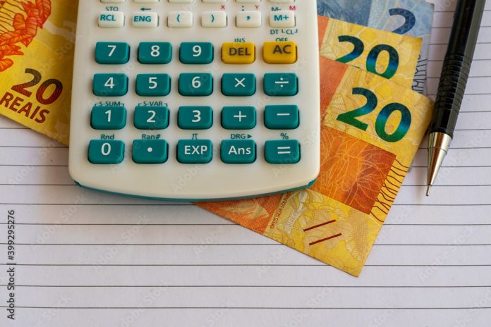 calculator, Brazilian money bills on sheet of paper with mechanical pencil