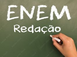 Female hand writing with chalk on empty green chalkboard. (translation portuguese: ENEM - National High School Exam Brazil - writing)