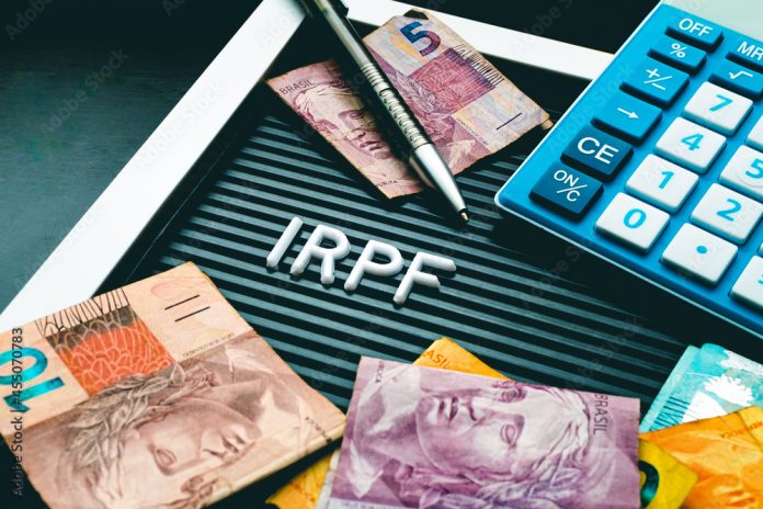 IRPF - Imposto de Renda da Pessoa Física. Economia brasileira. Palavra IRPF formada em uma quadro com letras e uma moeda de 1 Real. Dinheiro, Brasil e Economia.