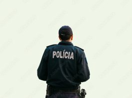 Isolated on white background a policeman is standing with his back in special clothes with the inscription Police in Portuguese and Slovak