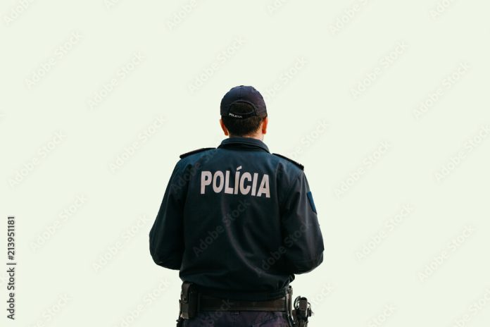 Isolated on white background a policeman is standing with his back in special clothes with the inscription Police in Portuguese and Slovak