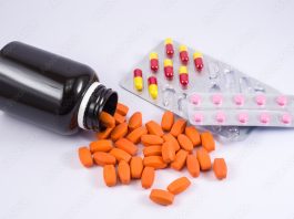 Frasco de remédios caído com comprimidos diversos em cápsulas, drogas.